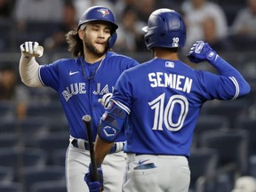 Blue Jays' Bo Bichette, left, celebrates his first inning home run against the Yankees with teammate Marcus Semien at Yankee Stadium in New York City, Thursday, Sept. 9, 2021.