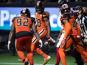 B.C. Lions' Boseko Lokombo (20) and Josh Banks (92) celebrate after Lokombo intercepted an Ottawa Redblacks' pass and scored a touchdown during the first half of a CFL game in Vancouver on Sept. 11.