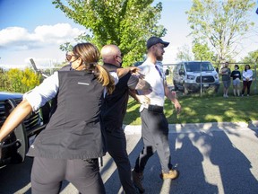 Members of the RCMP remove a protestor during a campaign stop by Prime Minister Justin Trudeau at the London Brewing Co-Operative in London, Ont. on Monday, Sept. 6, 2021. (Derek Ruttan/The London Free Press)