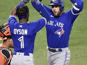 George Springer of the Toronto Blue Jays celebrates with Jarrod Dyson after hitting a go-head two-run home run in the seventh inning of the first game of a doublheader against the Baltimore Orioles on Sept. 11, 2021.