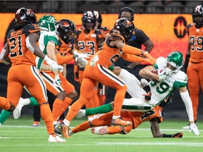 Saskatchewan Roughriders' Kian Schaffer-Baker, front right, is tackled by B.C. Lions' Marcus Sayles during the first half of a CFL football game in Vancouver, on Friday, Sept. 24, 2021.