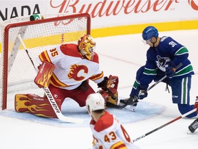 Calgary Flames goalie Adam Werner (35) stops Vancouver Canucks' Alex Chiasson (39) during the first period of a pre-season NHL hockey game in Abbotsford on Monday.