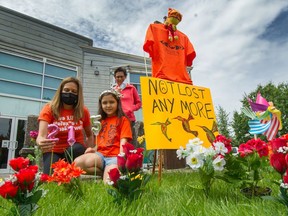 Seven-year-old Eliya Sparrow and Karen Grant (front-left) wearing orange shirts in Vancouver in May 2021, in tribute to those who were buried at the Kamloops residential school.