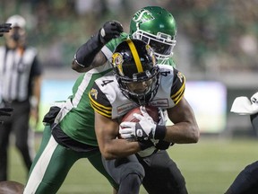 Saskatchewan Roughriders defensive end A.C. Leonard, shown here tackling on Papi White of the Hamilton Tiger-Cats, has been suspended by the CFL for two games for failing to provide a sample for drug testing. TROY FLEECE / Regina Leader-Post