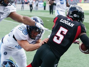 Stefan Logan #5 of the Ottawa Redblacks is pushed out of bounds by Nakas Onyeka (#6) and Jake Reinhart (#58) of the Toronto Argonauts in 2019.