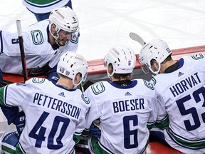 Vancouver Canucks J.T. Miller, Elias Pettersson, Brock Boeser and Bo Horvat talk strategy during the first period of an NHL game on Feb. 17, 2021.