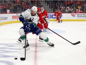 J.T. Miller, foreground, of the Vancouver Canucks battles for the puck against Filip Hronek of the Red Wings at Little Caesars Arena on Oct. 16 in Detroit.