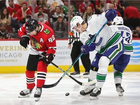 Patrick Kane, left, of the Chicago Blackhawks and Tyler Myers of the Vancouver Canucks battle for the puck at the United Center on Oct. 21 in Chicago.
