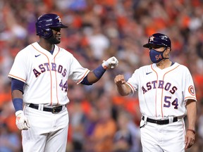 Yordan Alvarez of the Houston Astros fist bumps first base coach Dan Firova after hitting a single against the Boston Red Sox during the eighth inning. He was named ALCS MVP.