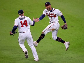 Atlanta's Eddie Rosario (right) is congratulated by Adam Duvall after catching a fly ball in the eighth inning in the Braves' Game 4 victory over the Houston at Truist Park on Saturday.