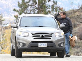 An RCMP officer speaks to a motorist Tuesday morning in Naramata not long after a man was shot in the nearby community of Indian Rock.