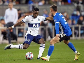 Vancouver Whitecaps forward Cristian Dajome passes while being defended by Earthquakes defender Paul Marie in the first half at PayPal Park in San Jose Saturday.