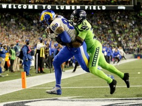 Rams tight end Tyler Higbee (left) catches a second half touchdown pass in front of Seahawks safety Jamal Adams at Lumen Field in Seattle, Thursday, Oct. 7, 2021.