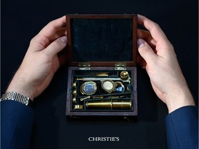 James Hyslop, Head of Scientific Instruments, Globes and Natural History at Christie's, demonstrates the Darwin Family Microscope, owned and used by the English naturalist and founder of the concept of evolution, Charles Darwin.