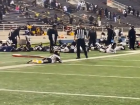 Players lie on the field as they take cover during a football game at Ladd-Peebles Stadium in Mobile, Alabama, on Friday night.