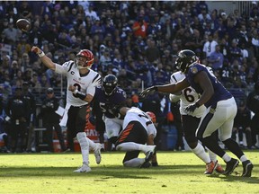 Cincinnati Bengals quarterback Joe Burrow (9) throws as offensive tackle Riley Reiff (71) blocks Baltimore Ravens outside linebacker Justin Houston (50) during the second half  at M&T Bank Stadium.