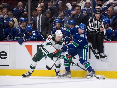 Minnesota Wild's Kirill Kaprizov (97), of Russia, and Vancouver Canucks' Tanner Pearson (7) vie for the puck during the first period of an NHL hockey game in Vancouver, on Tuesday, October 26, 2021.