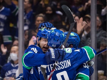 Vancouver Canucks' Alex Chiasson, back left, Elias Pettersson, of Sweden, and Bo Horvat celebrate Chiasson's goal against the Minnesota Wild during the second period of an NHL hockey game in Vancouver, on Tuesday, October 26, 2021.