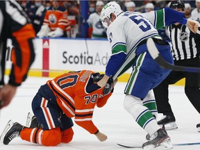 Vancouver Canucks defencemen Tyler Myers (57) and Edmonton Oilers forward Colton Scevior (70) fight during the second period at Rogers Place.