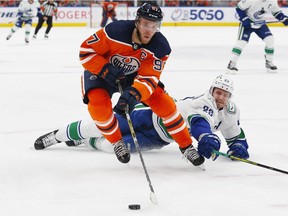 Oilers forward Connor McDavid carries the puck around Vancouver Canucks defenceman Oliver Ekman-Larsson at Rogers Place in Edmonton on Oct. 13.