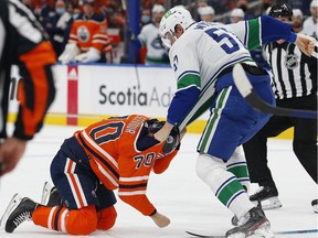 Oct 13, 2021; Edmonton, Alberta, CAN; Vancouver Canucks defensemen Tyler Myers (57) and Edmonton Oilers forward Colton Scevior (70) fight during the second period at Rogers Place.