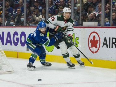 Oct 26, 2021; Vancouver, British Columbia, CAN; Vancouver Canucks forward Conor Garland (8) checks Minnesota Wild defenseman Jonas Brodin (25) in the first period at Rogers Arena. Mandatory Credit: Bob Frid-USA TODAY Sports