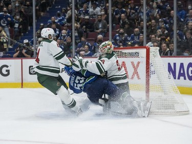 Oct 26, 2021; Vancouver, British Columbia, CAN; Minnesota Wild defenseman Jon Merrill (4) checks Vancouver Canucks forward Bo Horvat (53) as Horvat scores on goalie Cam Talbot (33) in the  third period at Rogers Arena. Minnesota won 3-2. Mandatory Credit: Bob Frid-USA TODAY Sports