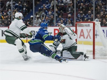 Oct 26, 2021; Vancouver, British Columbia, CAN; Minnesota Wild defenseman Jon Merrill (4) checks Vancouver Canucks forward Bo Horvat (53) as Horvat scores on goalie Cam Talbot (33) in the  third period at Rogers Arena. Minnesota won 3-2. Mandatory Credit: Bob Frid-USA TODAY Sports