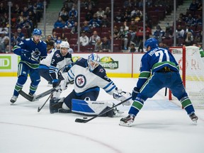 Winnipeg Jets goalie Mikhail Berdin (30) makes a save against Vancouver Canucks forward Nils Hoglander (21) in the second period at Rogers Arena.