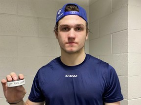 Abbotsford Canucks forward Danila Klimovich poses with the puck after scoring his first AHL goal on Saturday night in Bakersfield.