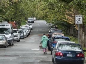 A motorists exits her vehicle after parking on a street in east Vancouver on Tuesday.