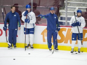 Canucks' assistant coaches Kyle Gustafson (left) and Brad Shaw with players at team practice at Rogers Arena on Wednesday, October 6, 2021.