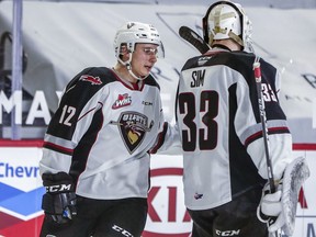 Vancouver Giant Adam Hall, shown checking in with goalie Drew Sim during a WHL game last season, says that as a 20-year-old he must ‘be a leader for the young guys.’