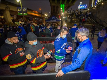 VANCOUVER, BC - Oct. 26, 2021  - Canucks fans show their vaccine passes outside Rogers Arena prior to game time  in Vancouver, BC, Oct. 26, 2021. 

(Arlen Redekop / PNG staff photo) (story by reporter) [PNG Merlin Archive]