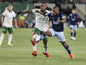 Vancouver Whitecaps forward Deiber Caicedo (7) battles for the ball with Portland Timbers midfielder George Fochive (20)  during the second half at Providence Park.