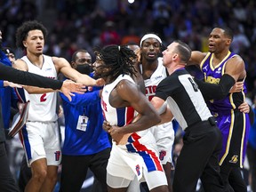 Isaiah Stewart #28 of the Detroit Pistons is restrained as he goes after LeBron James #6 of the Los Angeles Lakers during the third quarter of the game at Little Caesars Arena on November 21, 2021 in Detroit, Michigan. NOTE TO USER: User expressly acknowledges and agrees that, by downloading and or using this photograph, User is consenting to the terms and conditions of the Getty Images License Agreement. (Photo by Nic Antaya/Getty Images) ORG XMIT: 775715045