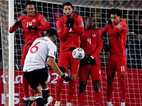 Team Canada's Mark Anthony Kaye (14) Steven Vitoria (5), Kamal Miller (4) and Tajon Buchanan (11) block a kick from Costa Rica's Oscar Duarte during a FIFA 2022 World Cup qualifier soccer match held at Commonwealth Stadium in Edmonton on Friday, Nov. 12, 2021.