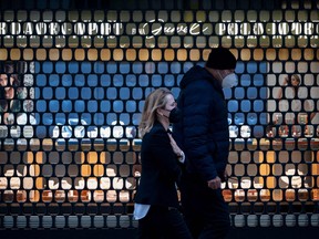 People walk past a closed jewelry store on the Graben, a street in the city centre of Vienna that is normally packed with crowds of people, in Vienna, Austria, on Nov. 22, 2021.