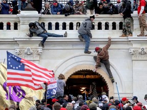 A mob of supporters of U.S. President Donald Trump fight with members of law enforcement at a door they broke open as they storm the U.S. Capitol Building in Washington, January 6, 2021.