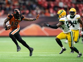 B.C. Lions' Dominique Rhymes, runs with the ball past Edmonton Elks' Darius Williams after making a reception in the first half of B.C.'s rout of Edmonton Friday night.