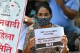 Activists of Student Federation of India (SFI) and All India Democratic Women's Association (AIDWA) hold placards during a protest against the alleged rape and murder of a nine-year-old girl, in New Delhi on August 4, 2021.