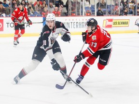 Vancouver Giants winger Zack Ostapchuk tries to block a shot from Portland Winterhawks defenceman Luca Cagnoni Wednesday in Portland.