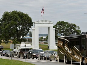 Travellers line up to enter Canada after border restrictions were loosened to allow fully vaccinated U.S. residents, after the coronavirus disease (COVID-19) pandemic forced an unprecedented 16-month ban that many businesses complained was crippling them, at the Peace Arch border crossing in Surrey, British Columbia, Canada August 9, 2021.