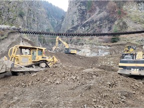 Crews work as CP Rail tracks are suspended above the washed out Tank Hill underpass of the Trans Canada Highway 1 after devastating rain storms caused flooding and landslides, northeast of Lytton, British Columbia.