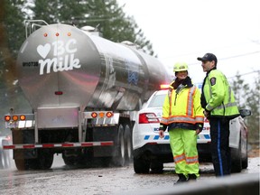 Trucks and other vehicles pass a police checkpoint on the newly-reopened Highway 7 between Mission and Agassiz, after rainstorms caused flooding and landslides across British Columbia, Canada November 18, 2021.