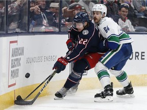 CP-Web. Columbus Blue Jackets' Jake Bean, left, tries to clear the puck as Vancouver Canucks' Tyler Motte defends during the third period of an NHL hockey game Friday, Nov. 26, 2021, in Columbus, Ohio.