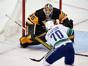 Pittsburgh Penguins goaltender Tristan Jarry (35) blocks a shot by Vancouver Canucks' Tanner Pearson (70) during the first period of an NHL hockey game in Pittsburgh, Wednesday, Nov. 24, 2021.