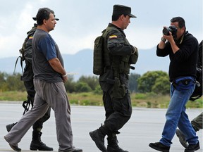Daniel Rendon Herrera (L), a.k.a. "Don Mario", is heavily escorted by police officers on April 15, 2009 in Bogota, Colombia.