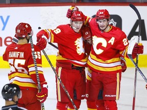 The Calgary Flames’ Matthew Tkachuk (centre) celebrates with Sean Monahan and Noah Hanifinafter scoring a goal against the Nashville Predators at the Scotiabank Saddledome in Calgary on Tuesday, Nov. 2, 2021.