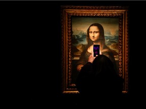 A visitor takes a photo of a copy of the Leonardo da Vinci's Mona Lisa, which will go up for auction on November 9, at the Artcurial auction house in Paris, France.